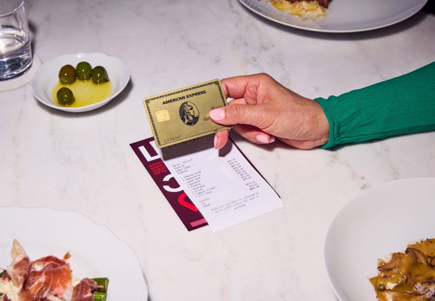 An American Express card is presented by an American Express® Card Member at a restaurant.